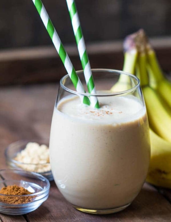 tan smoothie in a stemless wineglass with a green & white straw