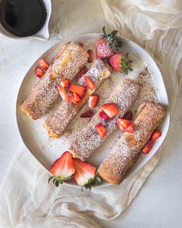 french toast on a white plate with strawberries