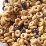 cheerios mixed with dried fruits and nuts in a large glass bowl