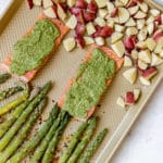 salmon with veggies on a gold sheet pan