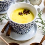 turmeric milk in a mug with star anise and cinnamon