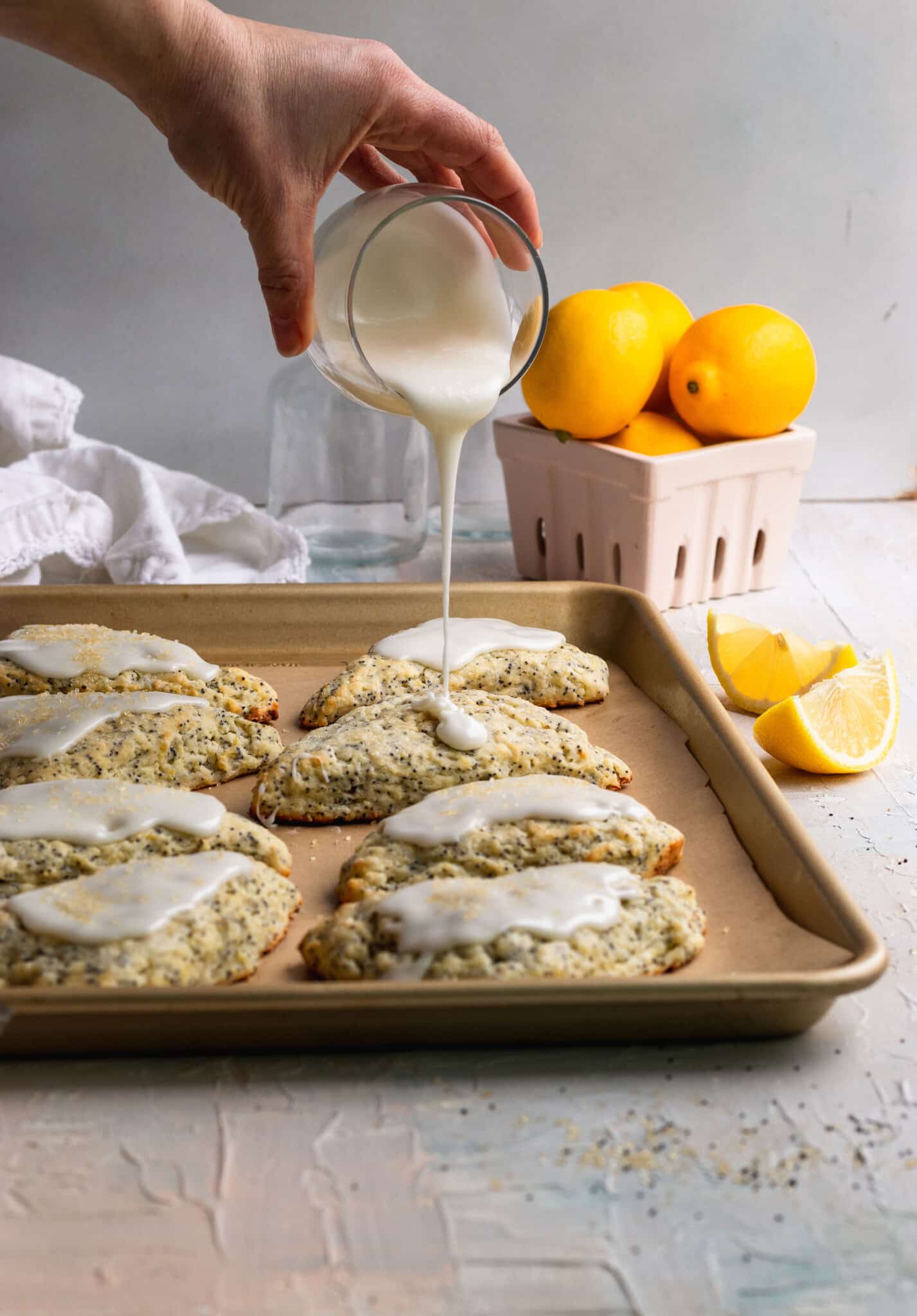 glaze being poured on lemon poppyseed scones