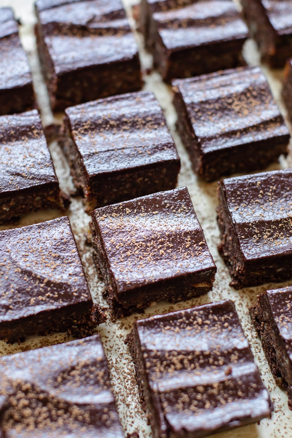 brownies on parchment paper dusted with cocoa powder