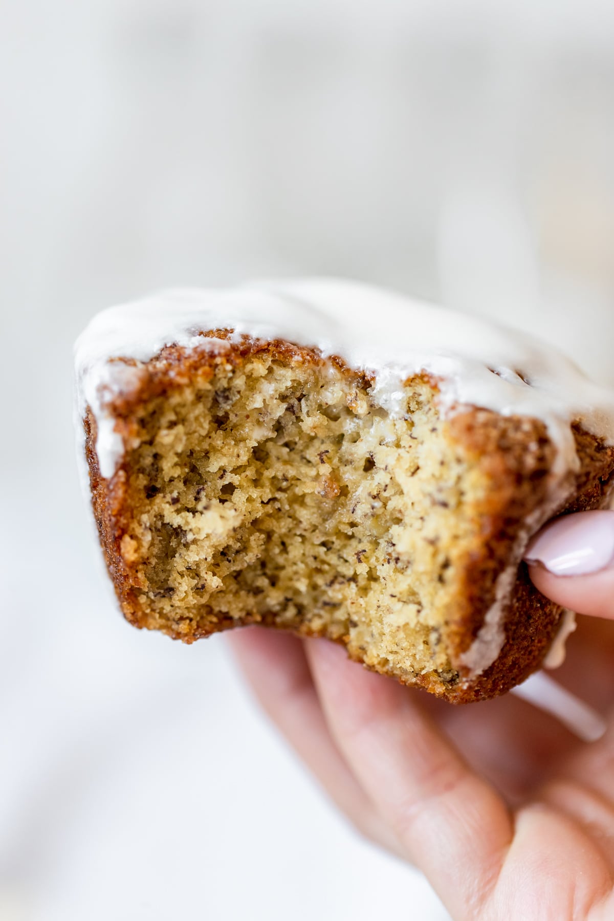 a womans hand holding a muffin