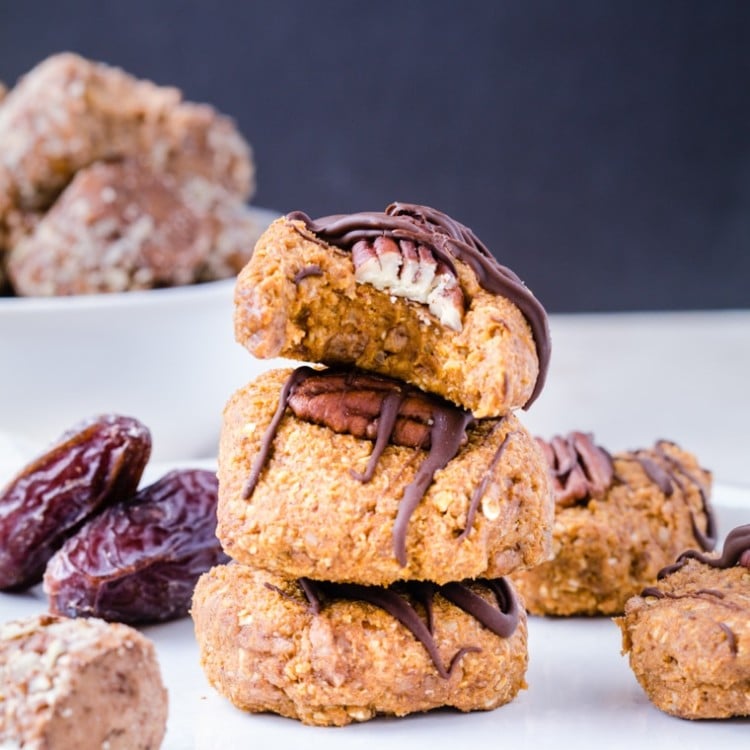 Pumpkin Cookies stacked on top of each other drizzled with dark chocolate.