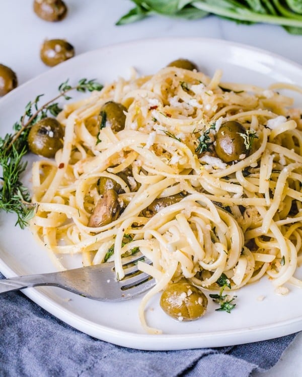 Herb Pasta Linguini on a plate mixed with fresh herbs and California Green Ripe Olives