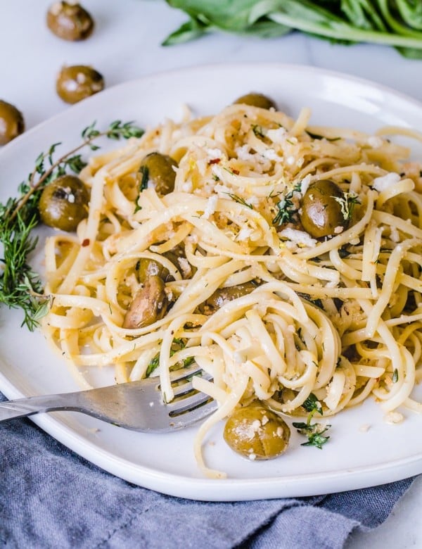 Herb Pasta Linguini on a plate mixed with fresh herbs and California Green Ripe Olives