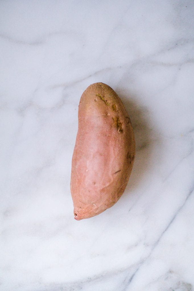 Sweet potato, not cooked, on a marble board