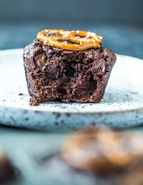A brownie bite on a plate with melted chocolate