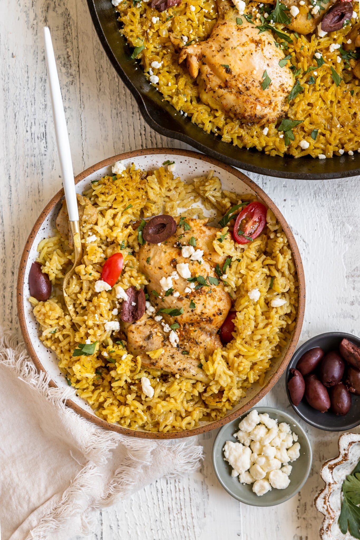 chicken and rice in a bowl garnished with kalamata olives and feta cheese