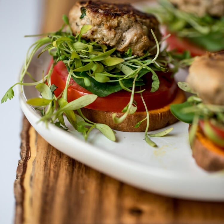 a turkey burger on a white plate with sweet potato