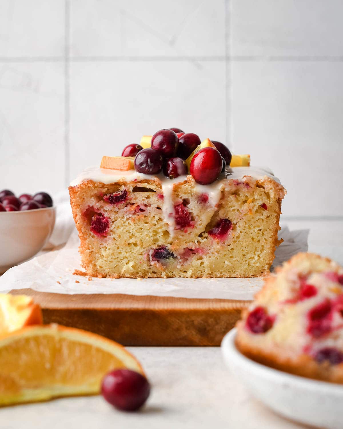 quick bread on a cutting board topped with cranberries