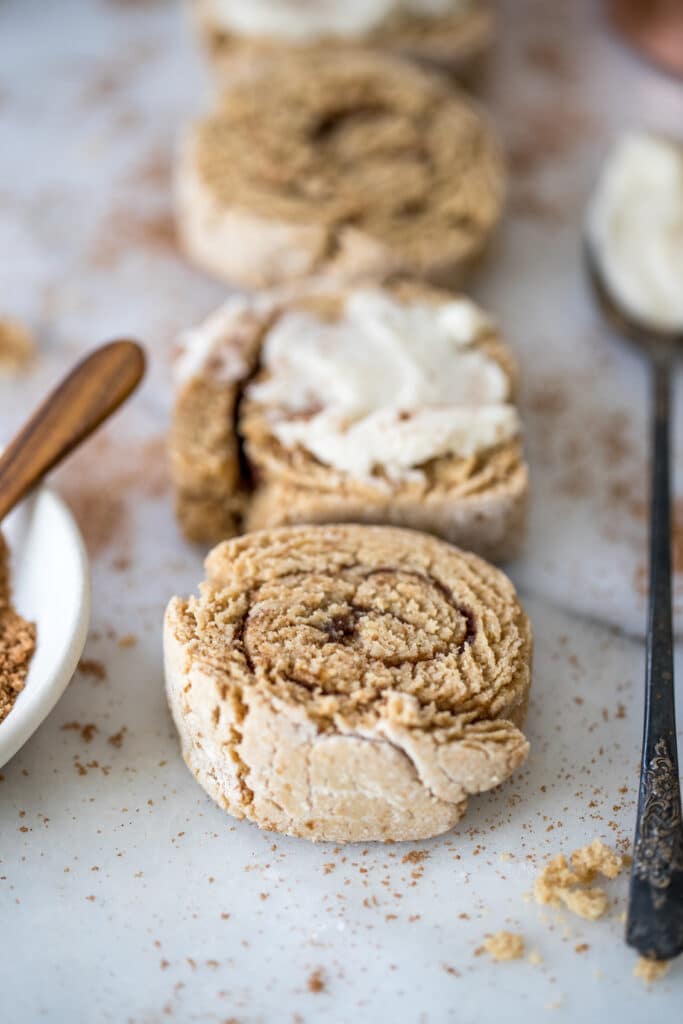 cinnamon rolls on a marble board with frosting on top