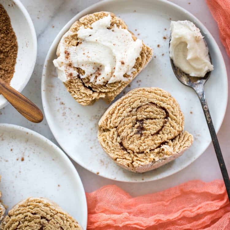 cinnamon rolls on a white plate with frosting