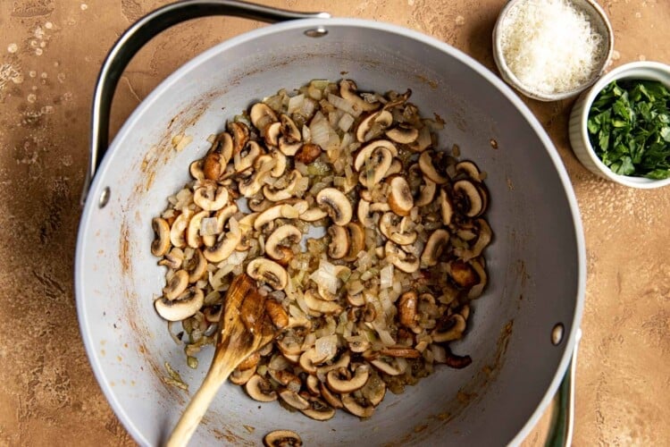 spoon with glazing onions in dutch oven pan