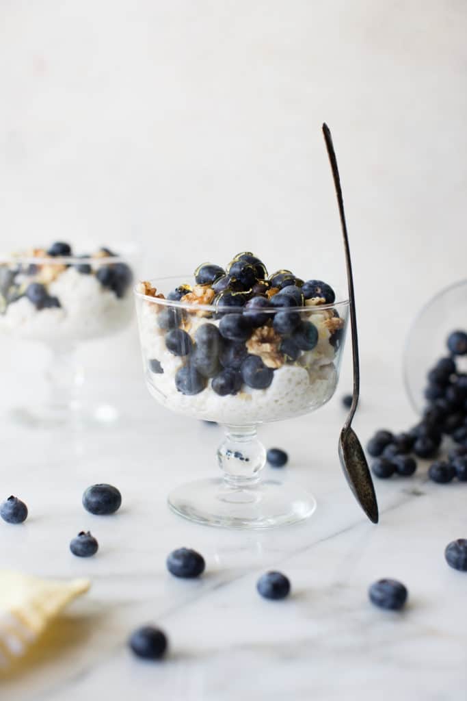 quinoa parfait in a glass parfait dish topped with blueberries