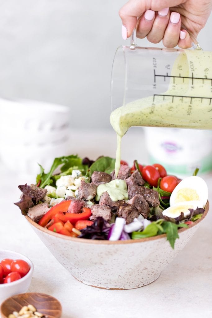 meal prep keto steak cobb salad with avocado dressing poured on top