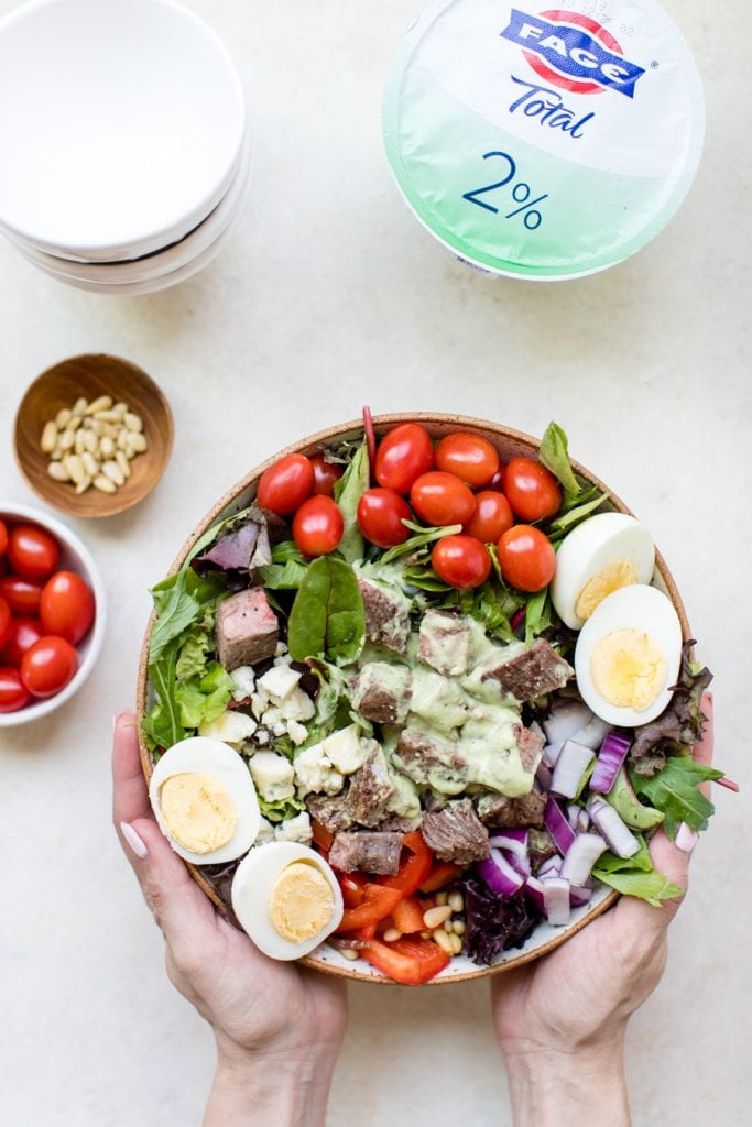 meal prep keto steak cobb salad with avocado dressing poured on top