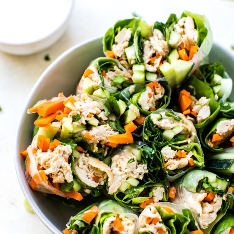 gluten free chicken summer rolls cut in half in a white bowl