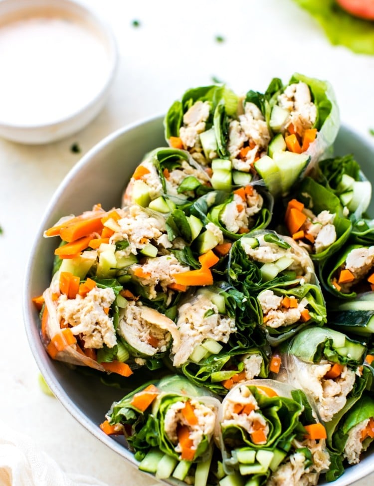 gluten free chicken summer rolls cut in half in a white bowl