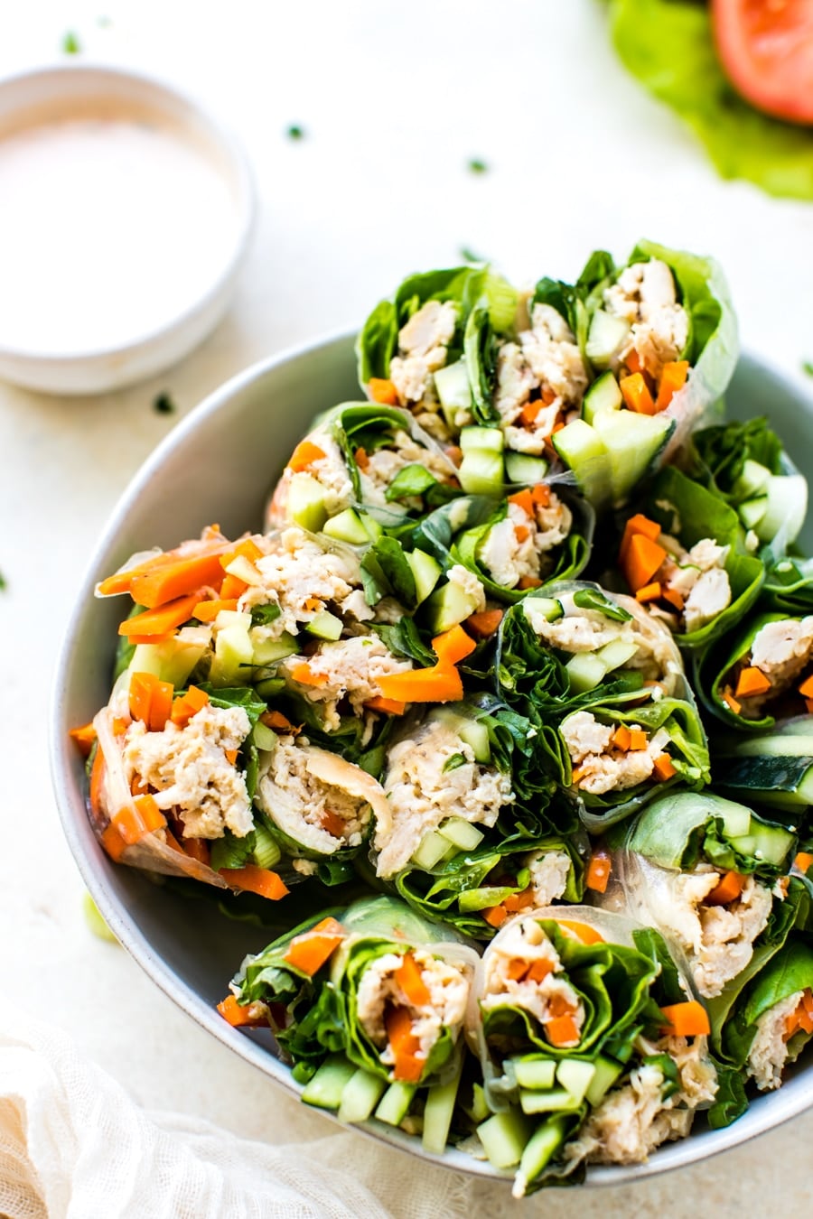 gluten free chicken summer rolls cut in half in a white bowl