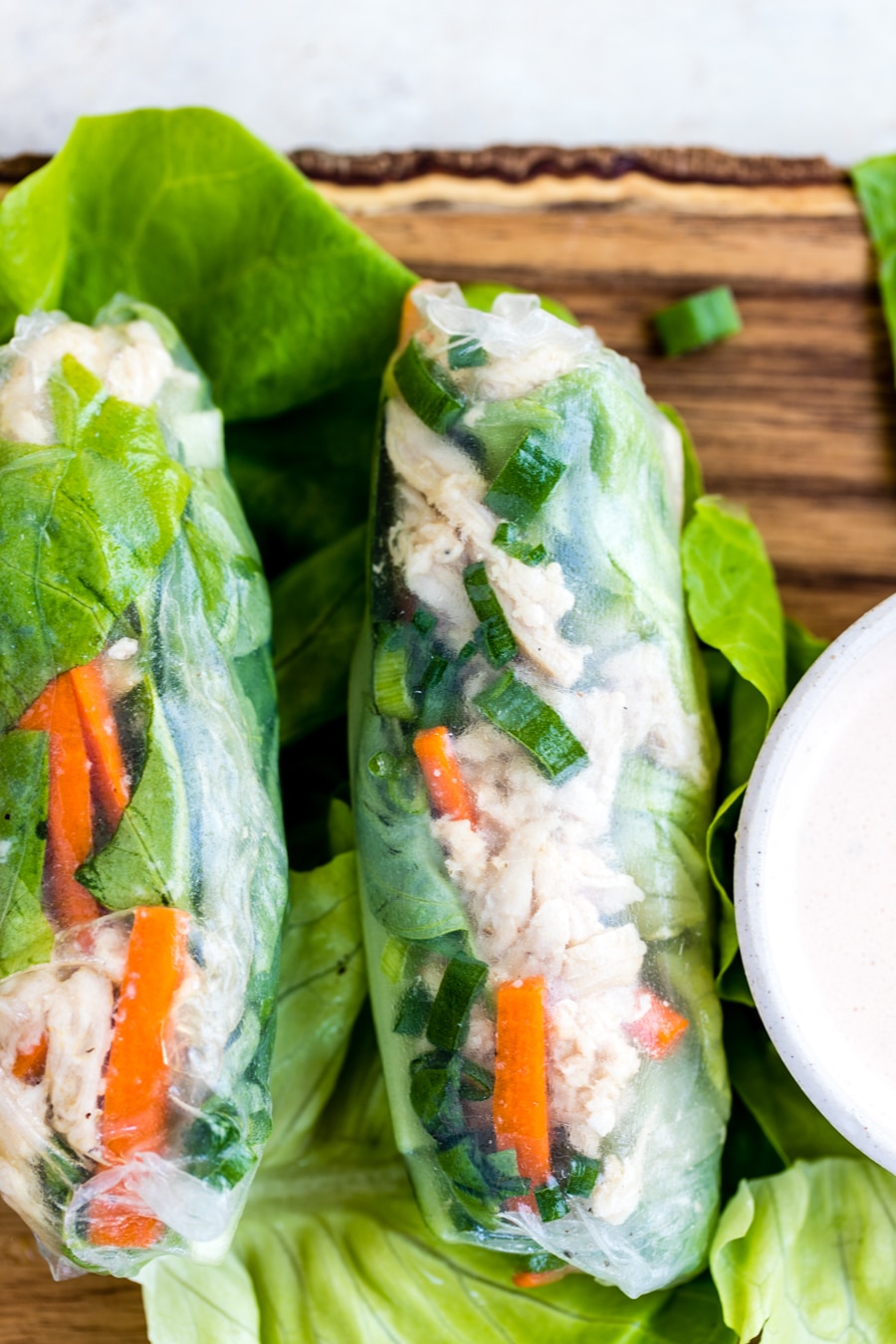 chicken summer rolls on a wood cutting board