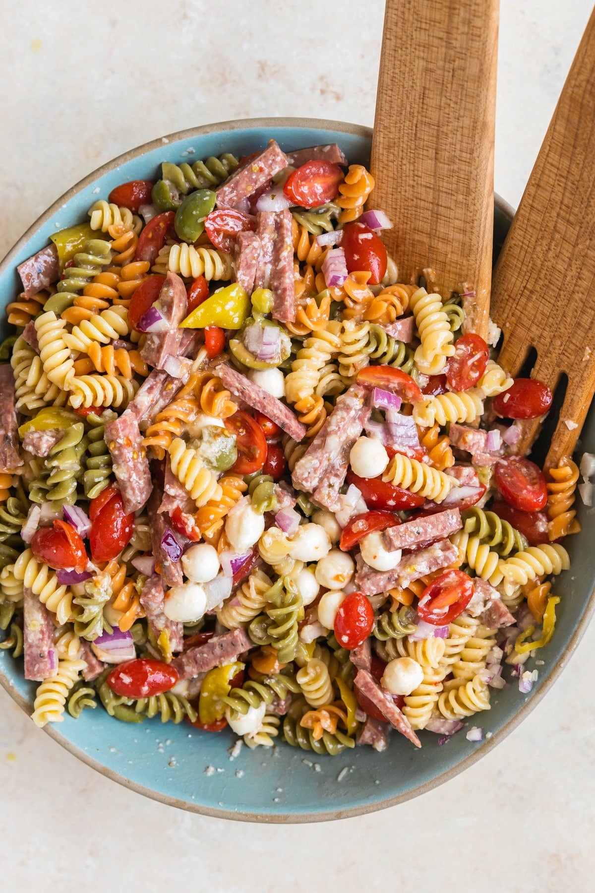 pasta in a bowl with sausage and tomatoes and cheese.