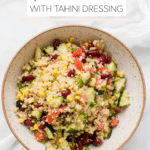 quinoa in a bowl with fresh veggies and a tahini lemon dressing