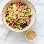 quinoa in a bowl with fresh veggies and a tahini lemon dressing
