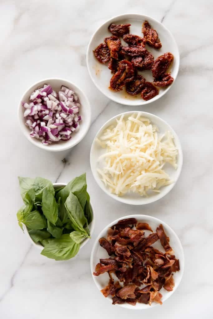 ingredients needed to make egg muffins on white plates