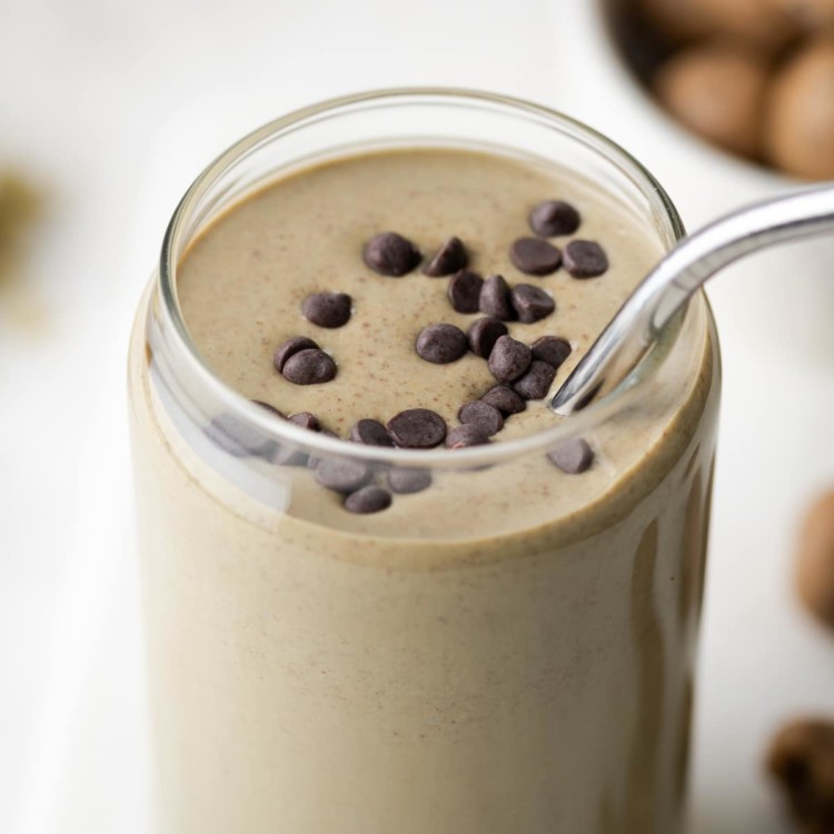 a smoothie in a glass cup garnished with chocolate chips