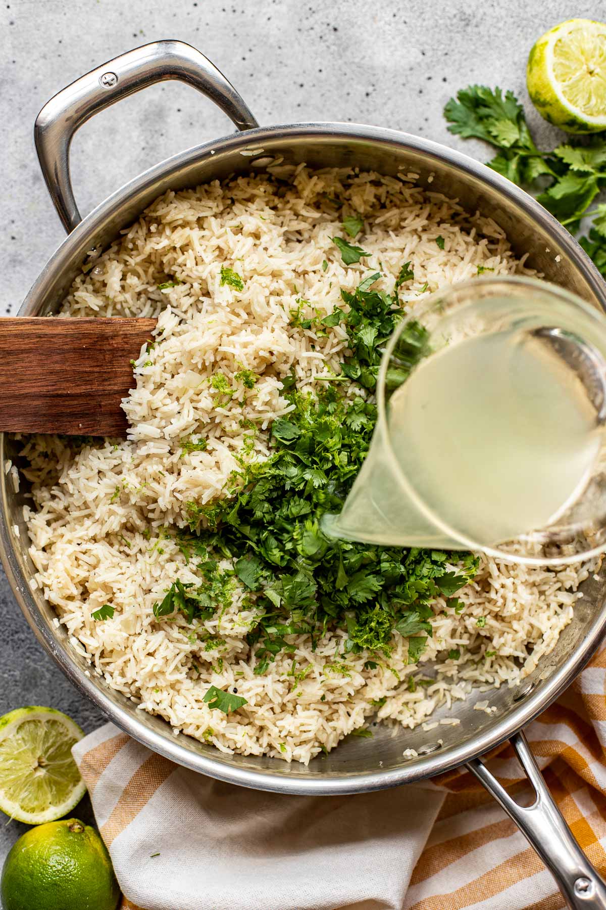 Broth being poured onto rice in a saute pan. 