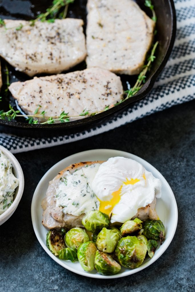 pork chops and eggs on a white plate