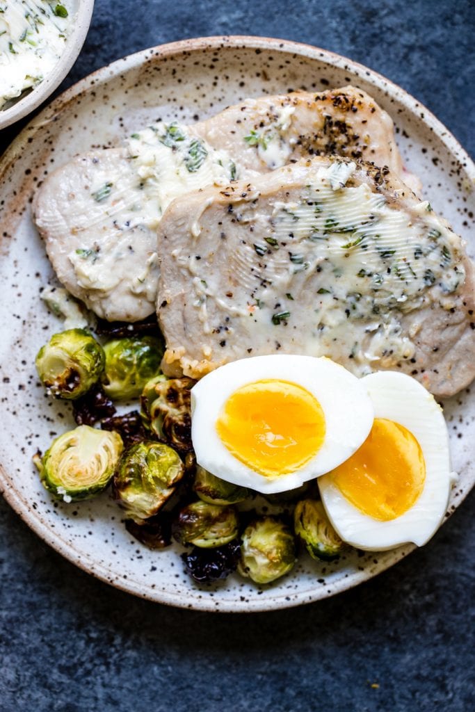 pork chops and eggs on a white plate