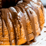 Bacardi rum cake on a cake stand with chocolate icing