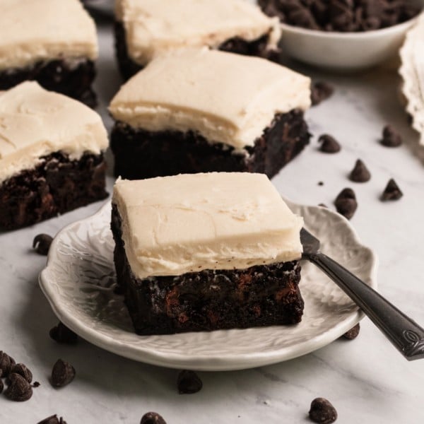 brownies with buttercream frosting on a marble board