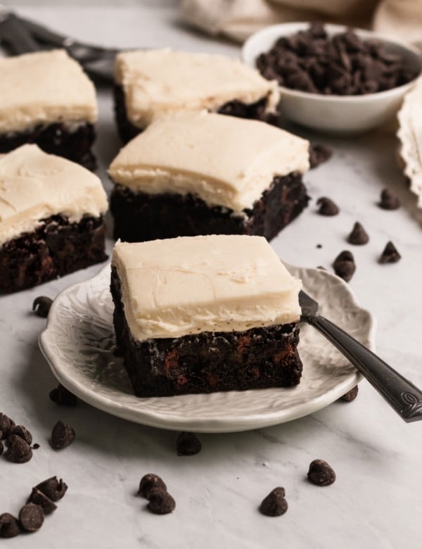 brownies with buttercream frosting on a marble board