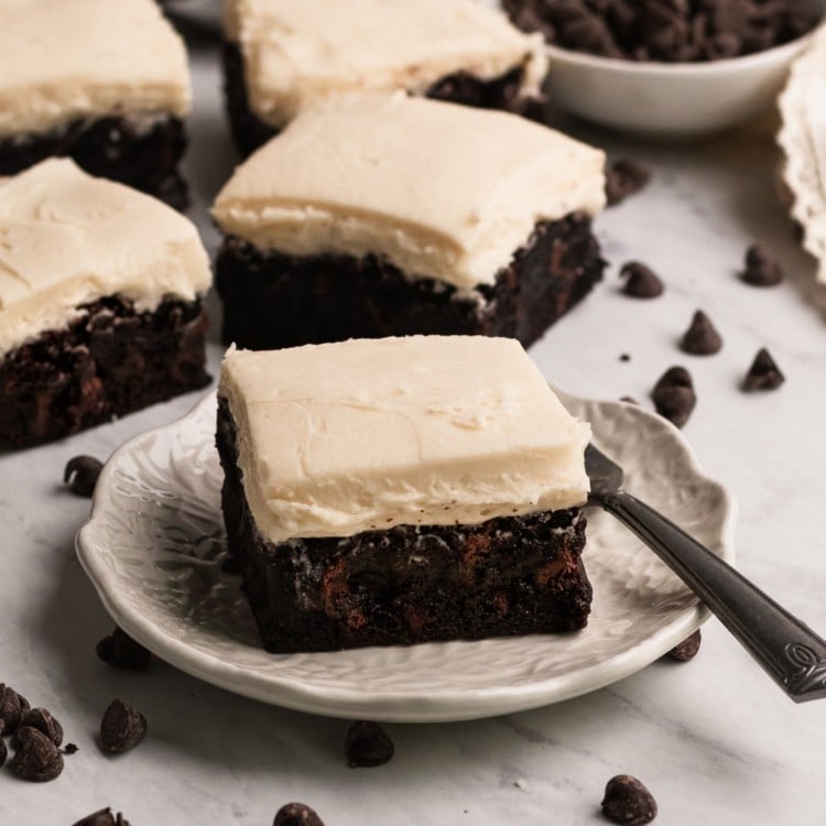 brownies with buttercream frosting on a marble board