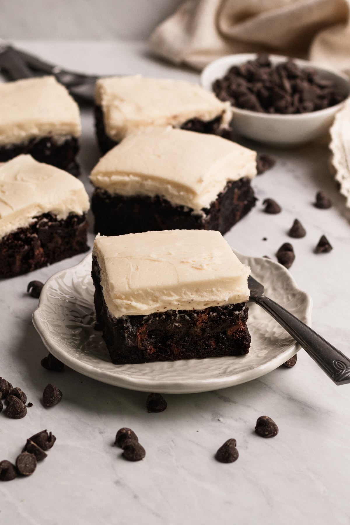 brownies with buttercream frosting on a marble board