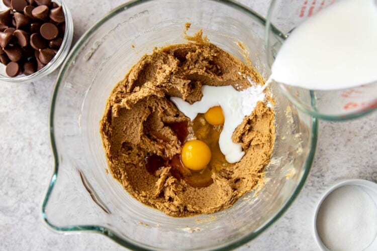 milk and egg being added to cookie dough mixture