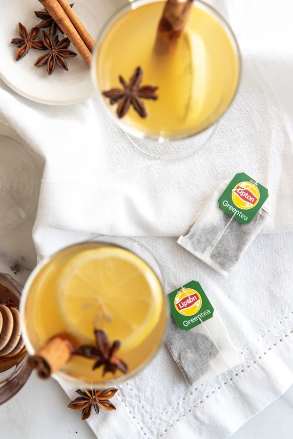 a lipton green tea hot toddy with whole star anise and a cinnamon stick and lemons