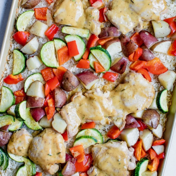 chicken rice and veggies on a gold baking sheet