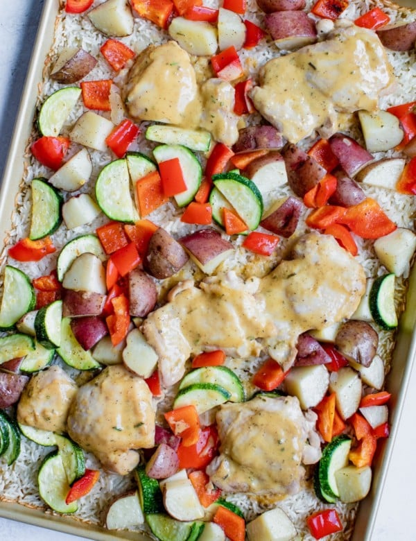 chicken rice and veggies on a gold baking sheet