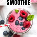 a berry smoothie in a glass topped with fresh berries