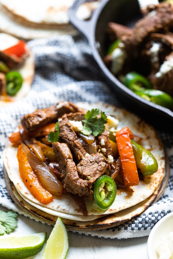 flank steak fajitas with a flour tortilla topped with cilantro