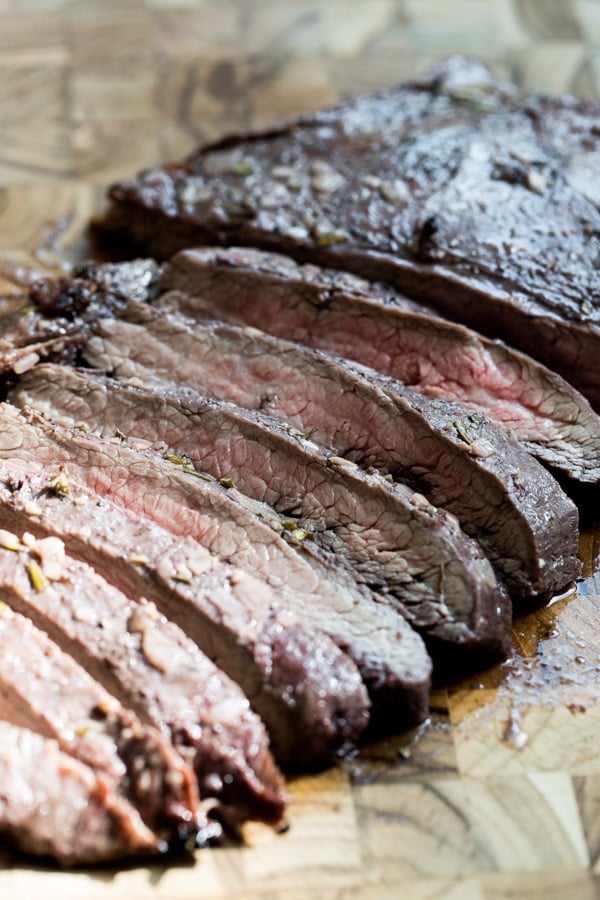 sliced baked flank steak on a cutting board