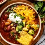 chili in a bowl with cheese and cornbread.