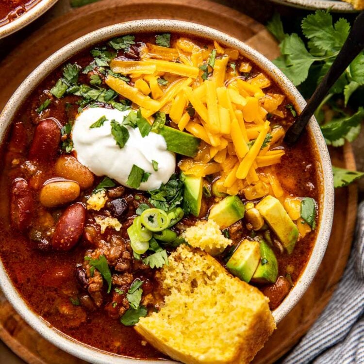 chili in a bowl with cheese and cornbread.