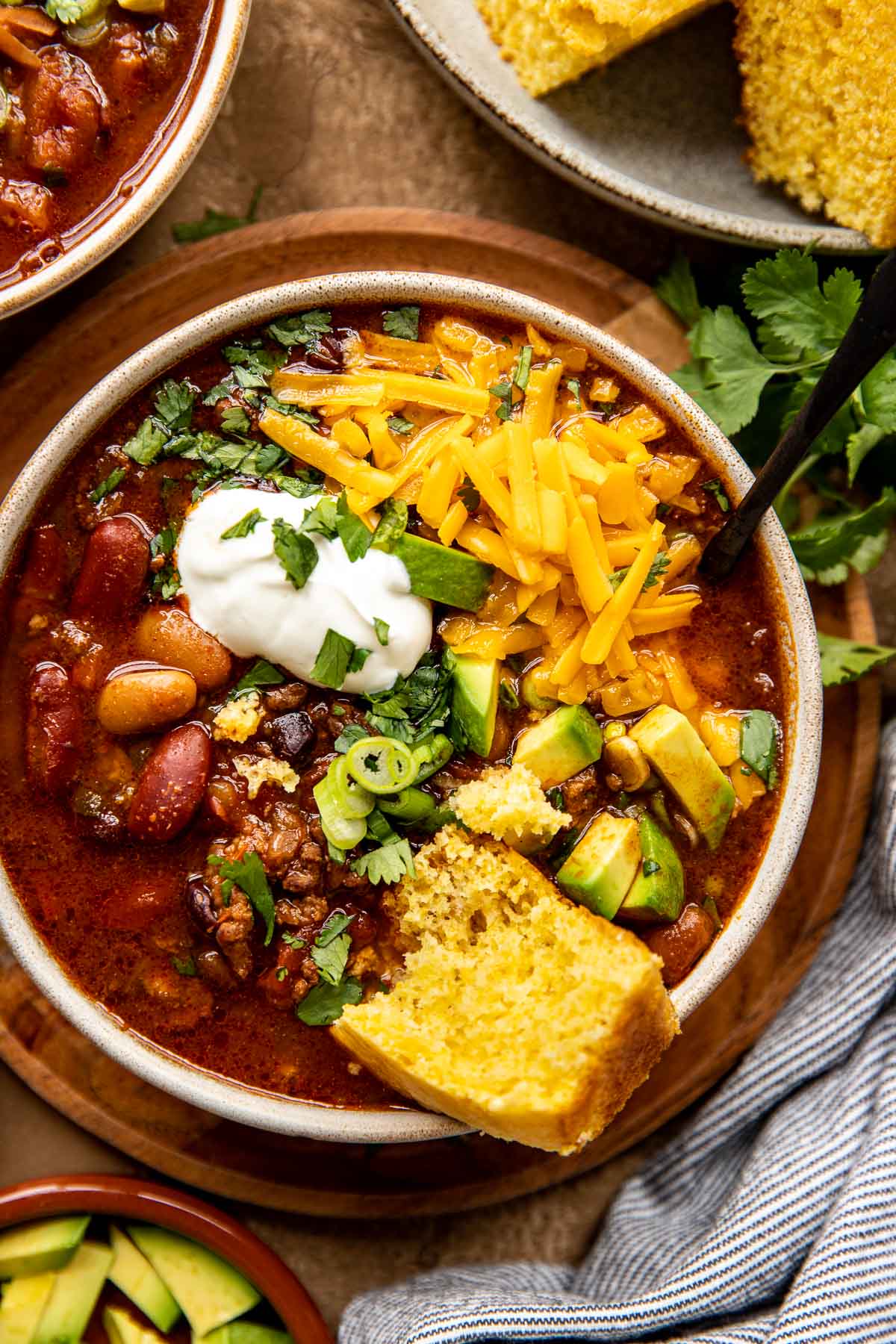 chili in a bowl with cheese and cornbread.