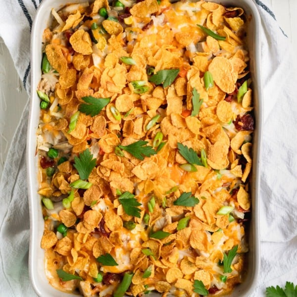 casserole in a casserole dish made with chicken and hash browns topped with cornflakes and fresh parsley